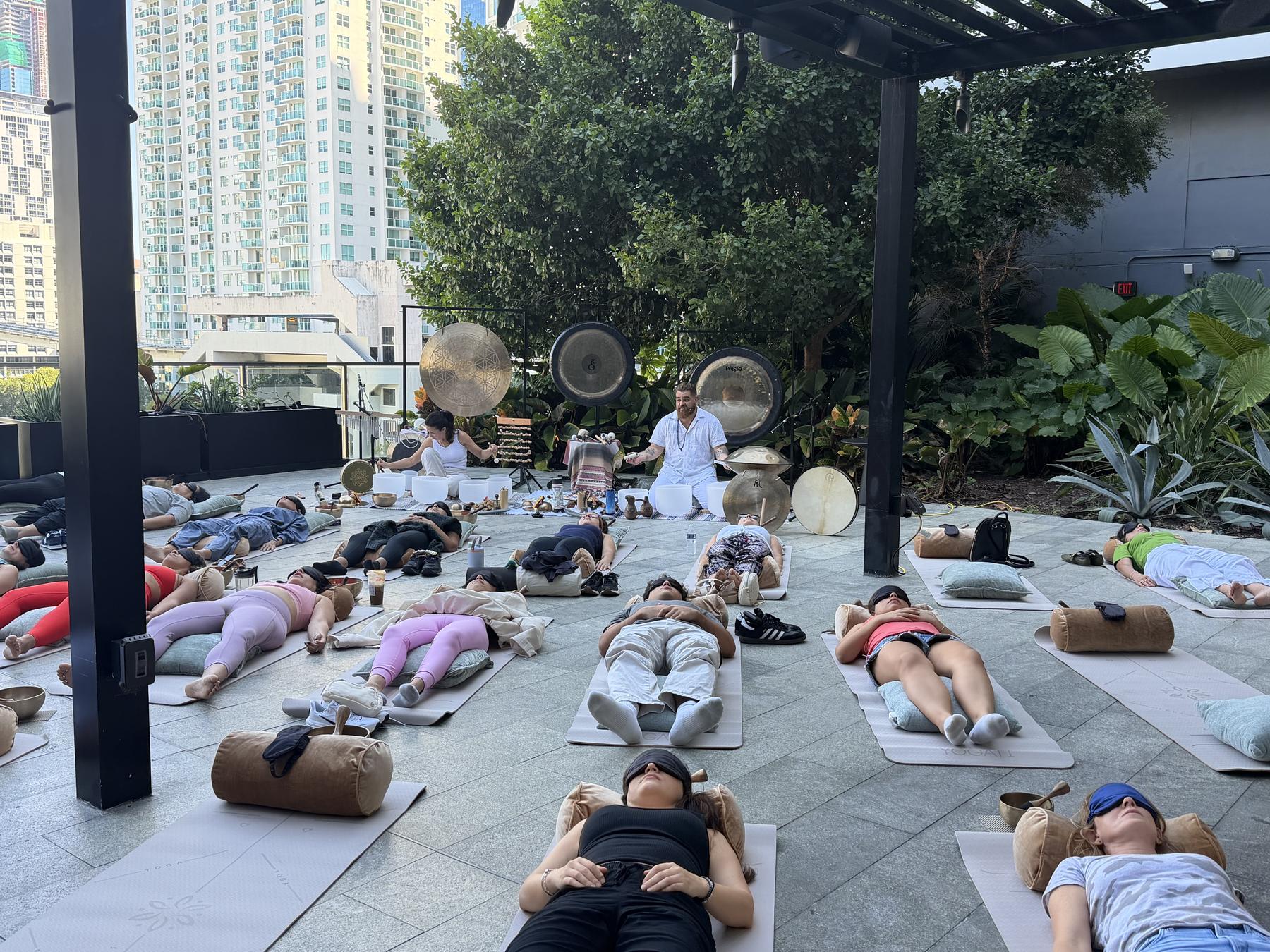 People resting on their mats on the terrace during a session