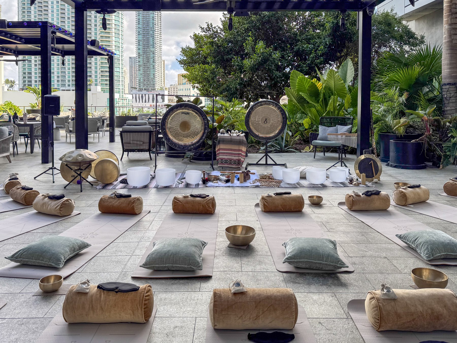 The terrace set with mats and bolsters, gongs and crystal bowls at the head of the room