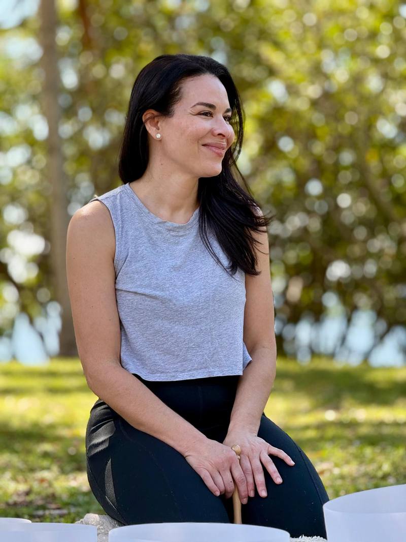 Karina Ríos seated with crystal singing bowls