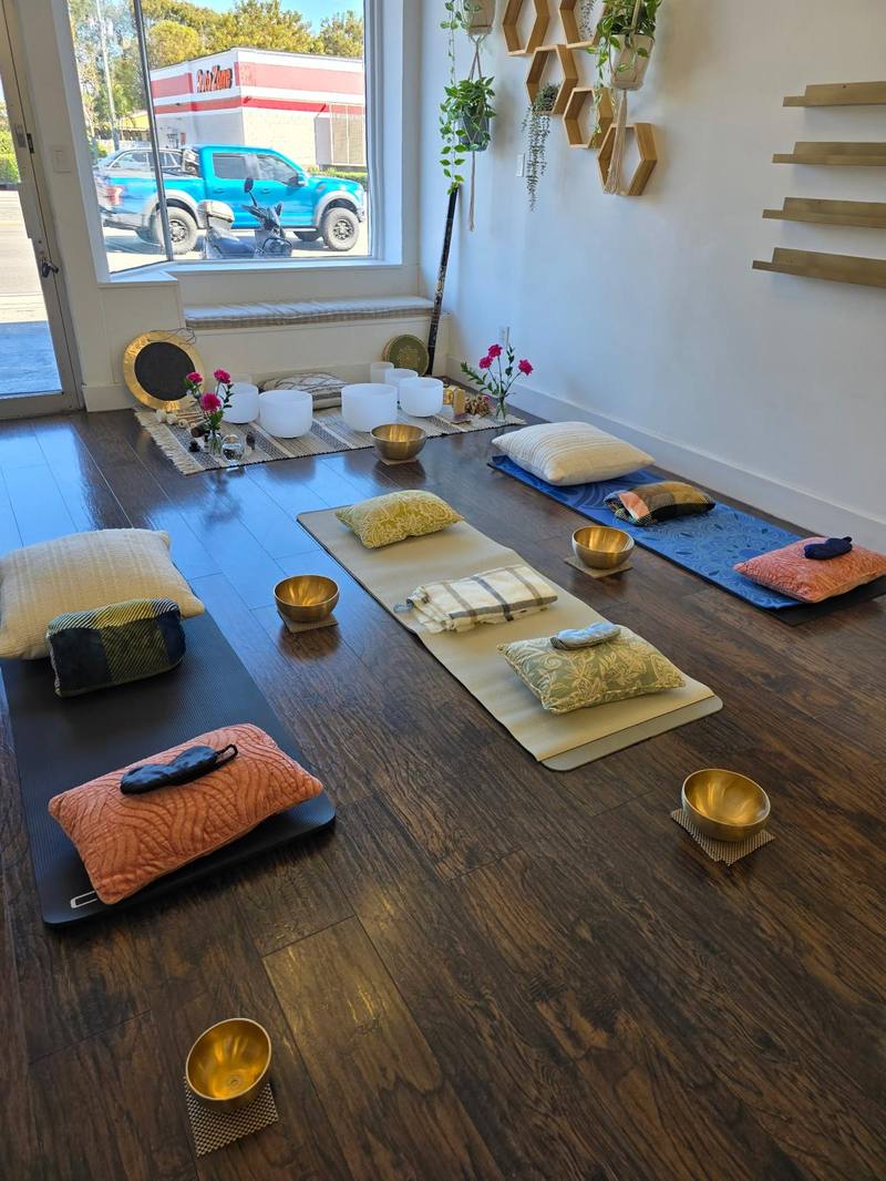 Espacio Alma Sonora prepared for a session — mats, cushions, and bowls in warm light